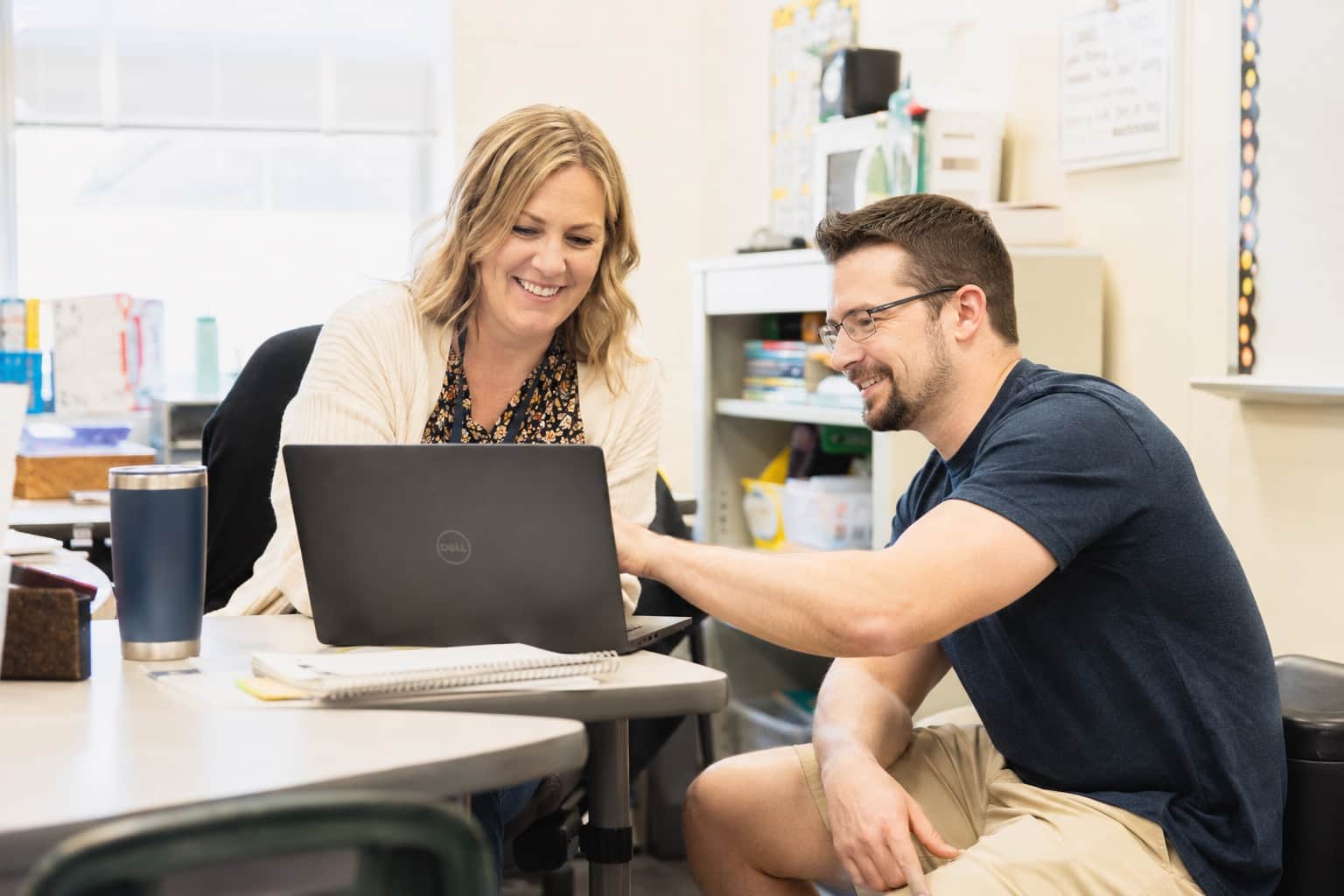 Suzor IT technician helping a staff member at her laptop